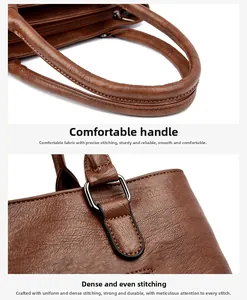 Detail of brown leather tote bag showing handle stitching and metal buckle hardware