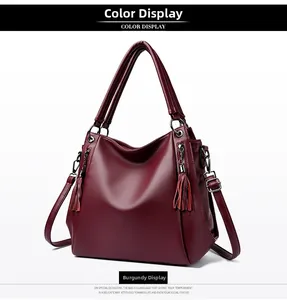 Detail of wine red tote bag featuring premium lychee texture leather and tassel charm