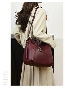 Détail du sac cabas bordeaux en cuir grainé avec charm feuille argentée et surpiqûres