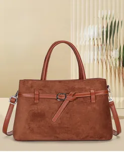 Detail shot of caramel brown matte leather tote bag with elegant metal buckle decoration