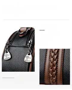 Detail of silver zipper with kangaroo logo and brown woven strap on black leather bag