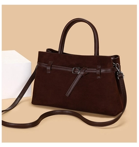 Detail of dark brown tote bag showing premium matte texture and metal buckle accents