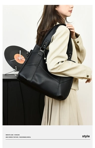 Sac cabas noir texture litchi avec pendentif perle porté par un mannequin