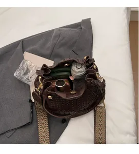 Top view of spacious interior in dark brown woven bucket bag with patterned strap
