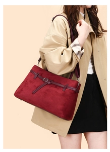 Close-up of burgundy frosted suede tote bag with leather strap and silver metal buckle
