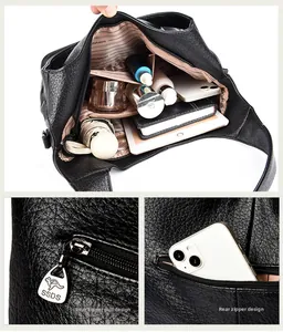 Macro view of interior compartments and rear zipper pocket on black litchi leather tote