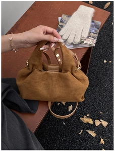 Close-up of brown suede cloud bag showing premium texture and golden ring buckle detail