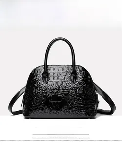 Front view showing glossy black crocodile pattern texture on a shell-shaped handbag
