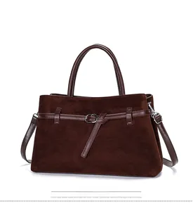 Close-up of matte suede texture and leather stitching details on a dark brown tote bag