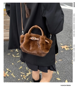 Detail der flauschigen braunen Kunstfell-Handtasche mit Ledergriff und Silberschnalle