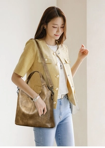 Close-up of metallic bronze tote bag with textured faux leather and adjustable straps