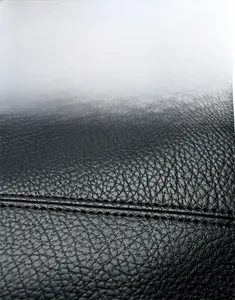 Gros plan sur la texture du cuir PU litchi noir avec coutures précises pour sac cabas