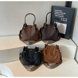 Detail of woven bucket bags with golden hardware and ethnic style wide straps