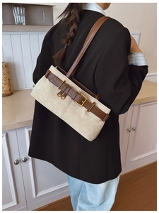Détail du sac sous le bras minimaliste avec texture daim beige et boucle de ceinture