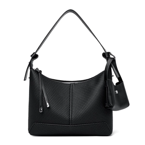 Minimalist black baguette bag with textured stripe embossing and wide shoulder strap