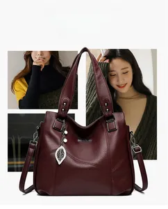Détails du sac cabas bordeaux avec texture de cuir litchi et pendentif feuille de perle