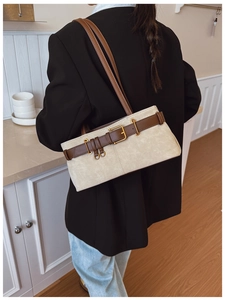 Détail du sac sous le bras minimaliste avec daim beige et accents de lanières en cuir brun