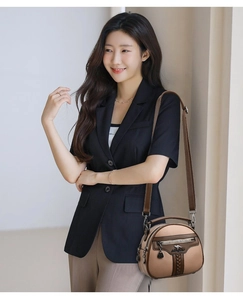 Detail of two-tone crossbody bag with lychee grain leather and adjustable strap