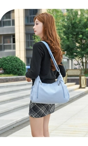 Light blue oxford fabric crossbody bag shown on a model for size and style reference