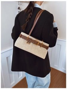 Détail d'un sac sous le bras vintage en daim crème avec une bandoulière en cuir brun