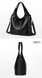 Detail view of black pebble leather tote with adjustable shoulder strap and metal hooks