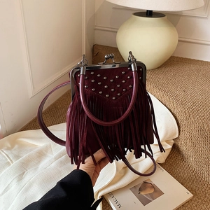 Detail of burgundy fringe handbag with metallic studs and vintage metal clasp closure