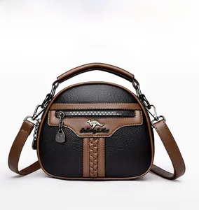 Front view of black and brown leather crossbody bag with metal logo and zipper detail