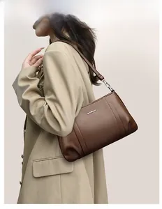 Detailed view of dark brown lychee grain leather crossbody bag with silver hardware