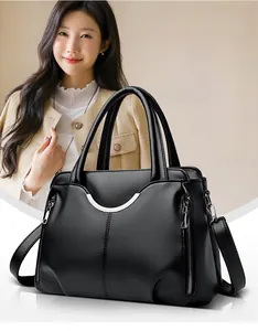 Détail du sac à main noir en cuir grainé avec boucle demi-lune argentée et zip latéral