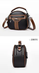 Detail view showing black and brown contrast leather texture and kangaroo logo on handbag