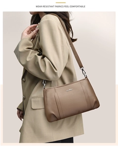 Close-up of brown litchi pattern leather crossbody bag with silver buckle details