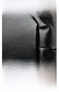 Détail du sac en cuir noir grainé litchi montrant la finition et les pièces métalliques