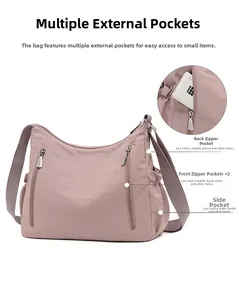 Detail view of pink nylon crossbody bag with multiple zip pockets and functional layout