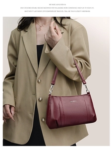 Detail of burgundy pebbled leather handbag with silver hardware and chain decoration