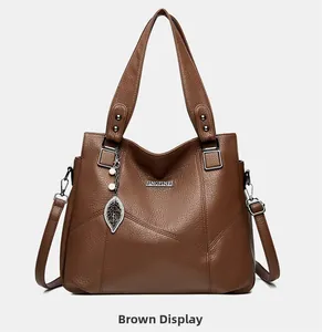 Détail du sac cabas marron jaune avec texture litchi et pendentif feuille en métal