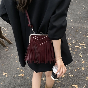 Detail showing burgundy suede fringe bag with silver studs and vintage kiss lock closure