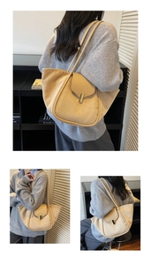 Macro detail of beige suede tote bag showing metal buckle closure and leather flap