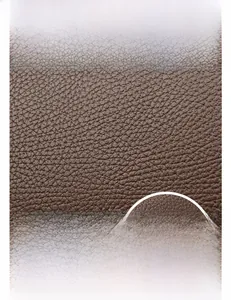 Close-up of deep brown lychee grain leather texture with silver metal yadier logo
