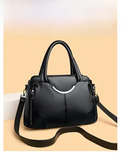 Détail du sac à main noir en cuir grainé avec décoration en métal argenté