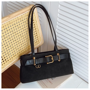 Détail d'un sac sous le bras en daim noir avec boucle dorée et bandoulière en cuir souple