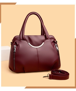 Détail d'un sac à main bordeaux en cuir foulonné avec garniture argentée et zips