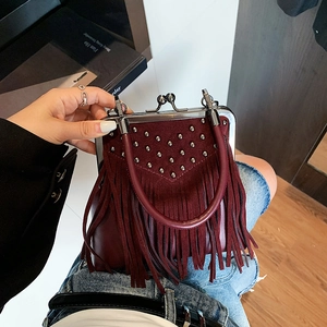 Fashionable burgundy tassel handbag with studs and retro metal frame in a stylish top view