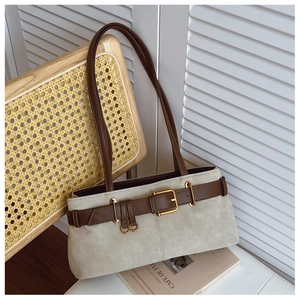 Détail du sac sous le bras en daim beige avec boucle en cuir marron et garnitures dorées