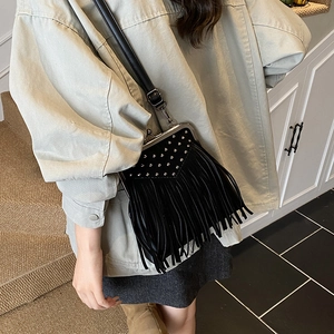 Detail of black fringe crossbody bag with silver studs and vintage metal frame closure