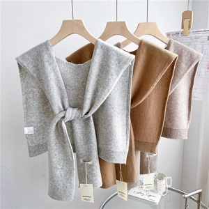 Elegant 100% pure wool knitted shawls in various earth tones hanging on wooden hangers