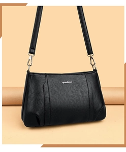 Detail shot of the textured black lychee leather and silver brand logo on the handbag