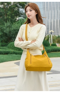 Detail view of large yellow oxford crossbody bag with multiple zipper pockets