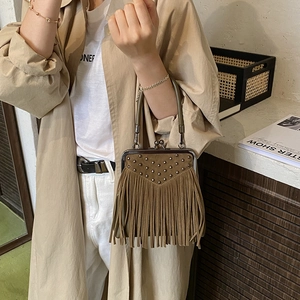 Detail of brown suede handbag with fringe tassels, metal rivets and vintage kiss-lock closure