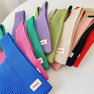 Detail von farbenfrohen Strick-Tote-Bags mit Waffelmuster und Hilldi-Markenetikett