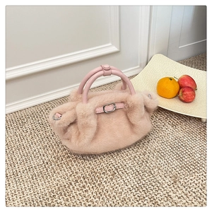 Detail der pinkfarbenen Kunstpelztasche mit Ledergriffen und silbernen Metallteilen